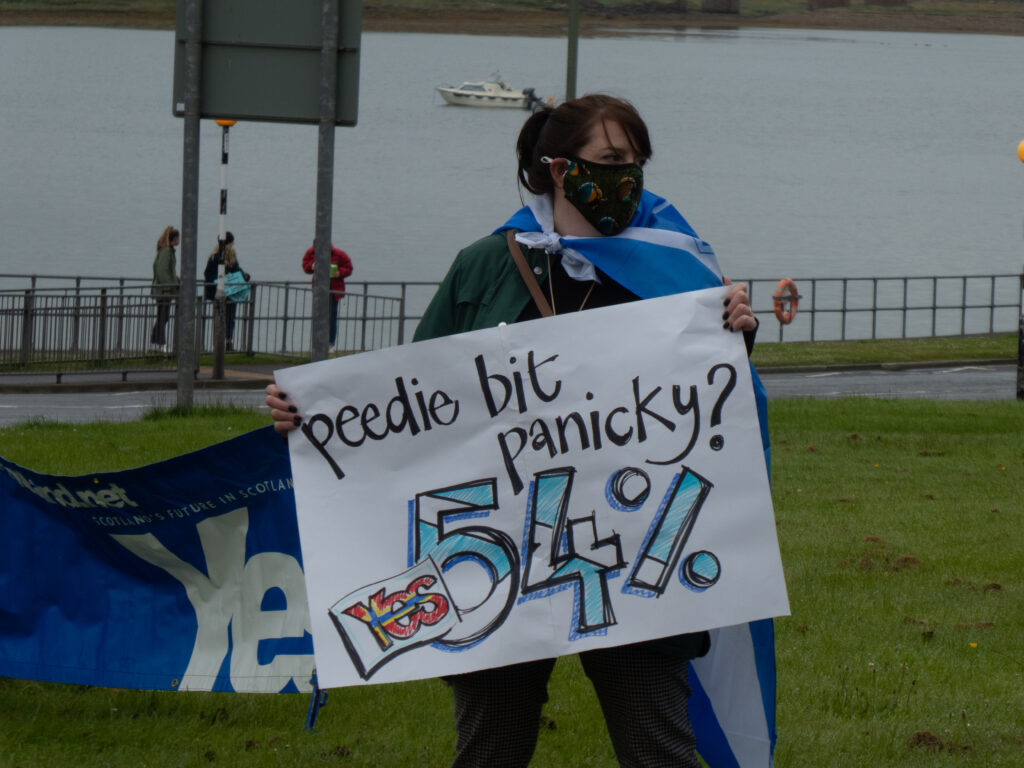 Protestor holding a sign "Peedie bit panicky? 54%"